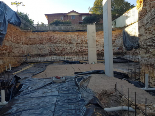 Residential excavation polythene sheets on a residential property excavation with sandstone walls